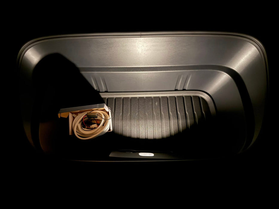 Trunk of a car with a folded blanket inside, on a black background