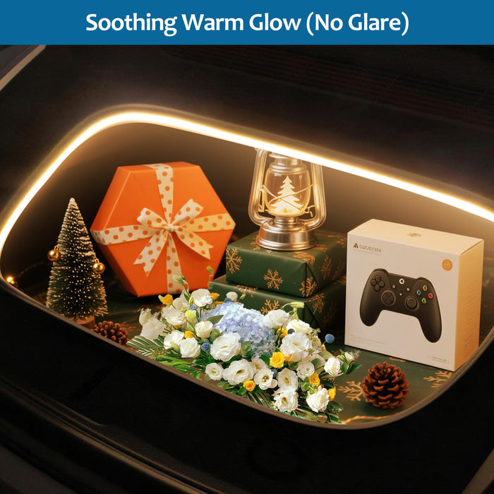 Decorative setup with a glowing strip light, gift box, lantern, flowers, and gaming controller on a dark surface in a 2026 Tesla Model Y Juniper Frunk LED Light