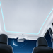 Gray motorized sunroof shade installed with cyan ambient lighting